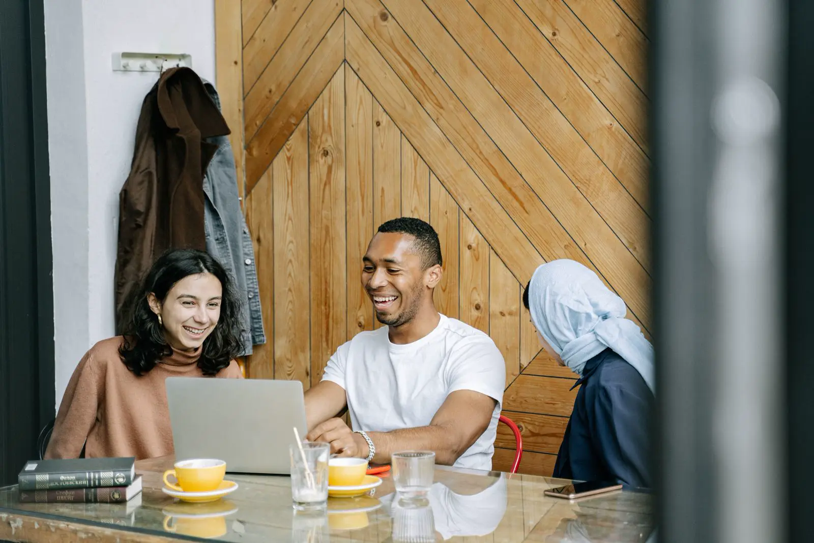 Equipe pequena rindo junto em volta de um notebook