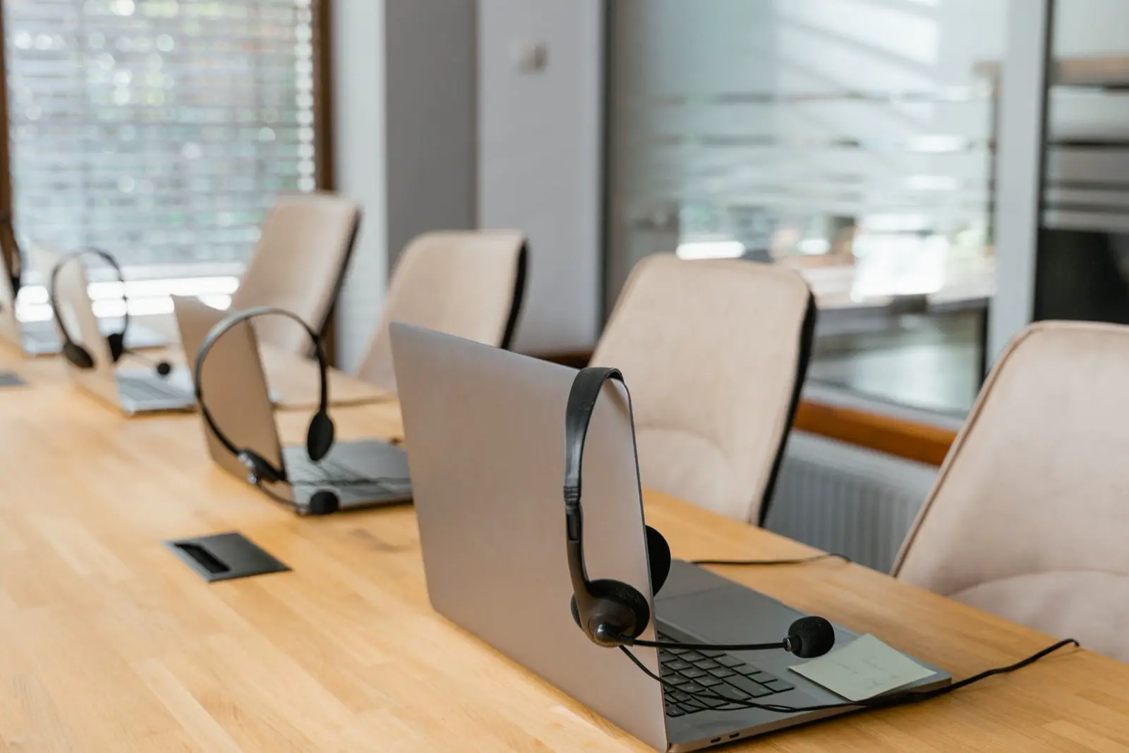 Central de atendimento vazia, com fones sobre a mesa